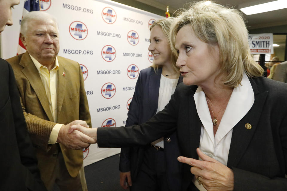 U.S. Sen. Cindy Hyde-Smith, R-Miss., right, thanks former Mississippi Republican Gov. Haley Barbour, left, for supporting her bid for re-election as her daughter Anna-Michael Smith, center, looks on, Friday, Jan. 3, 2020, at state GOP headquarters in Jackson, Miss. Hyde-Smith filed papers to run at party headquarters, with many Republican statewide elected officials in attendance. She is expected to campaign by emphasizing her loyalty to President Donald Trump. (AP Photo/Rogelio V. Solis)