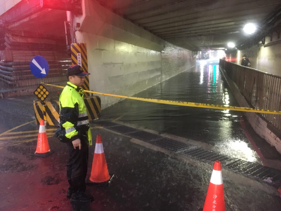 新北市8日午後強降雨造成汐止部分地區積水，中興路上的涵洞積水嚴重，警方派員到場拉起封鎖線並在旁警戒，以防車輛誤入。（中央社/民眾提供）