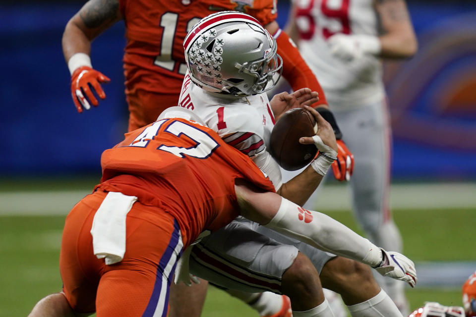 Ohio State quarterback Justin Fields gets hit by Clemson linebacker James Skalski during the first half of the Sugar Bowl NCAA college football game Friday, Jan. 1, 2021, in New Orleans. Skalski was ejected from the game for targeting. (AP Photo/Gerald Herbert)