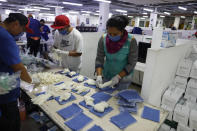 City workers sort gloves and masks as they prepare medical supply kits for home deliveries to households with a member suffering from symptoms of COVID-19, in Mexico City, Thursday, April 9, 2020. To help halt the spread of the new coronavirus, the Mexican megalopolis is making home deliveries to households with a symptomatic person, providing kits containing food staples, antibacterial gel, paracetamol, a thermometer, and benefits cards with a balance of 1000 pesos (around $42). (AP Photo/Rebecca Blackwell)