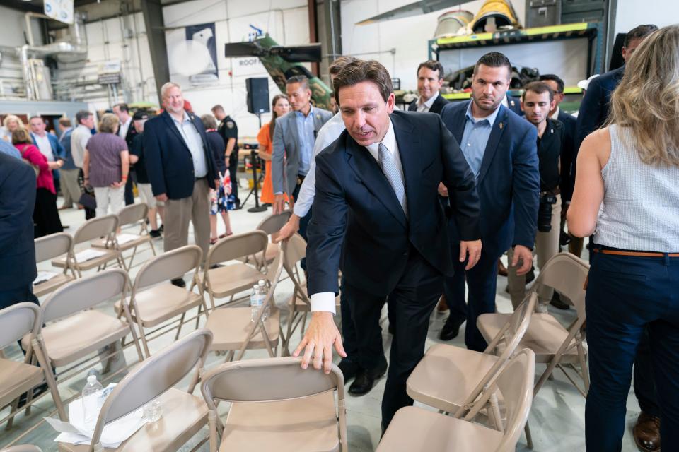 Florida Gov. Ron DeSantis, campaigning in the Republican presidential race in West Columbia, S.C., on July 18, 2023, moves chairs out of his way after a news conference.