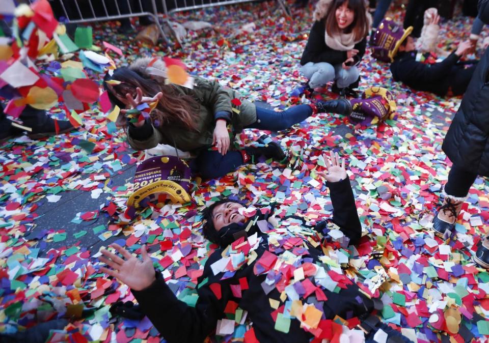 Revelers throw confetti on themselves after after celebrating the new year in Times Square, Sunday, Jan. 1, 2017, in New York. (AP Photo/Julio Cortez)