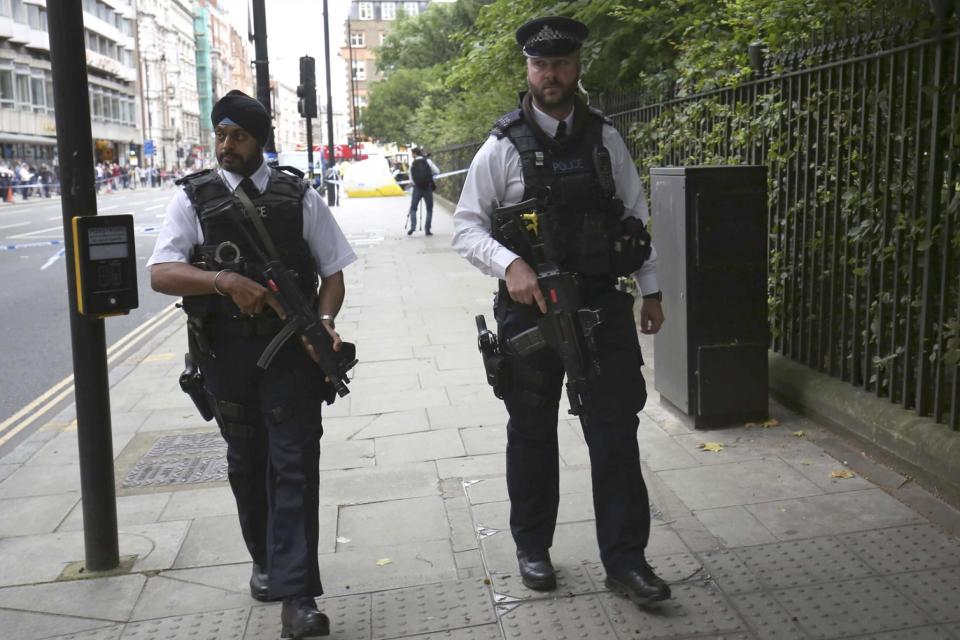 Armed police officers patrol past the scene of the knife attack in Russell Square (Reuters)