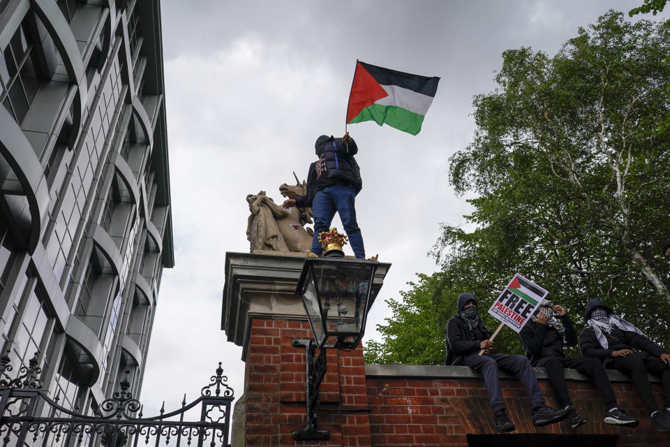 People hold placards and Palestinian flags during a march in solidarity with the Palestinian people amid the ongoing conflict with Israel, during a demonstration in London, Saturday, May 15, 2021. (AP Photo/Alberto Pezzali)