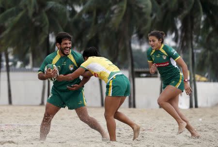 Members of Brazil's rugby team play rugby as they take part in the opening of a new rugby pitch which is installed on Copacabana beach in Rio de Janeiro, Brazil, June 24, 2015. REUTERS/Sergio Moraes