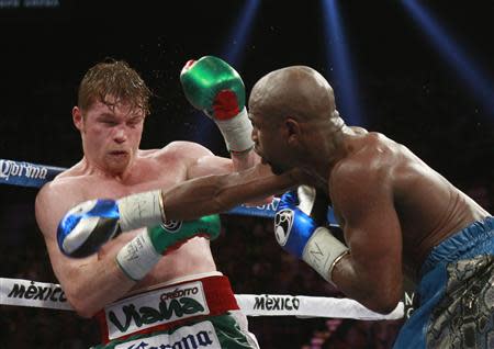 Canelo Alvarez (L) of Mexico takes a punch from Floyd Mayweather Jr. of the U.S. during their WBC/WBA 154-pound title fight at the MGM Grand Garden Arena in Las Vegas, Nevada, September 14, 2013. REUTERS/Steve Marcus