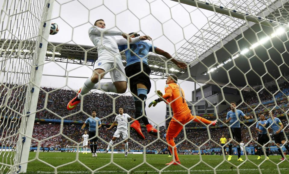 England's Wayne Rooney heads the ball into the crossbar during the 2014 World Cup Group D soccer match between Uruguay and England at the Corinthians arena