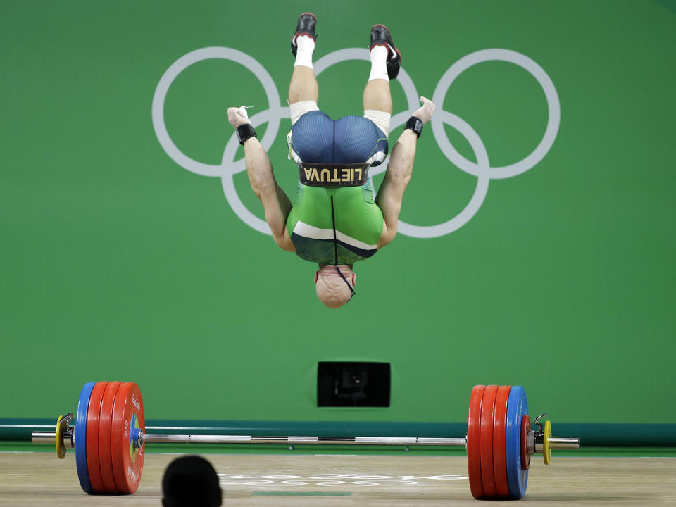 <p>Aurimas Didzbalis, of Lithuania, does a flip after his final lift of the night in the men’s 94kg weightlifting competition at the 2016 Summer Olympics in Rio de Janeiro, Brazil, Saturday, Aug. 13, 2016. (AP Photo/Mike Groll) </p>