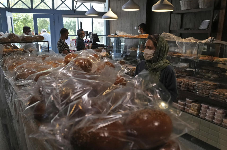 A customer looks at display cases in a bakery in Tehran, Iran, Wednesday, May 11, 2022. Iran abruptly raised prices as much as 300% for a variety of staples such as cooking oil, chicken, eggs and milk on Thursday. (AP Photo/Vahid Salemi)