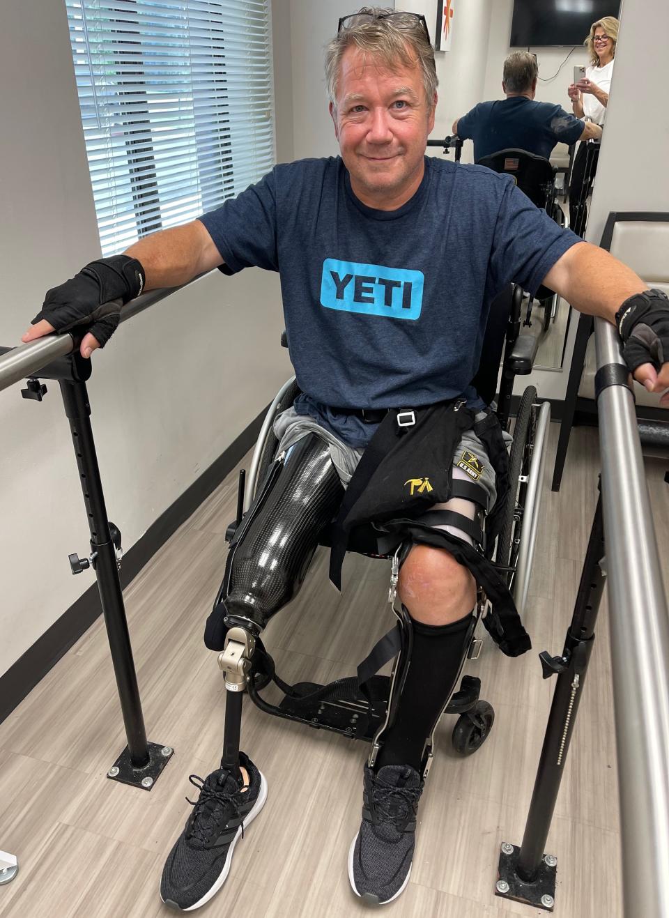Scott Spitnale getting fitted for a new prosthetic in August 2022 at the Hanger Clinic in Towson, Md. The reflection of his wife, Laura, can be seen in the mirror.