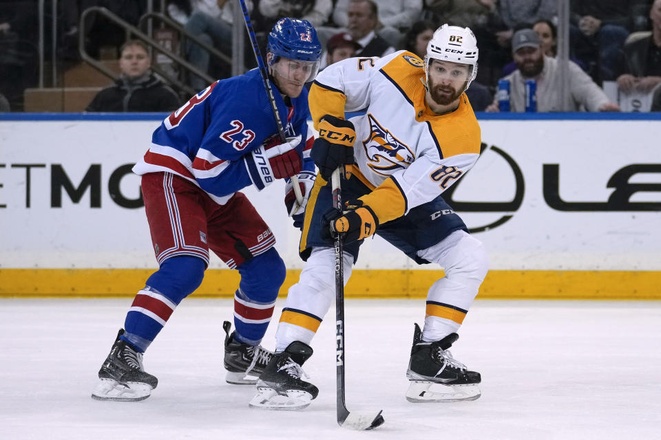 Nashville Predators center Tommy Novak (82) is defended by New York Rangers defenseman Adam Fox (23) during the second period of an NHL hockey game Sunday, March 19, 2023, in New York. (AP Photo/Bryan Woolston)