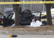 FBI and police investigators search the area around a car that was used the previous night by two gunmen, whose bodies lie covered by a tarpaulin, at the site of an exhibition in Garland, Texas May 4, 2015. REUTERS/Laura Buckman