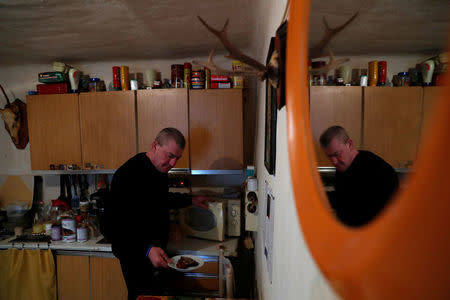 Laszlo Reisch, 48, prepares his lunch at home in Hosszuheteny, Hungary, March 26, 2018. Picture taken March 26, 2018. REUTERS/Bernadett Szabo