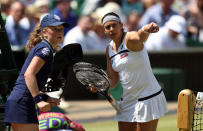 France's Marion Bartoli points something out to a ballgirl during her match against Germany's Sabine Lisicki during day twelve of the Wimbledon Championships at The All England Lawn Tennis and Croquet Club, Wimbledon.