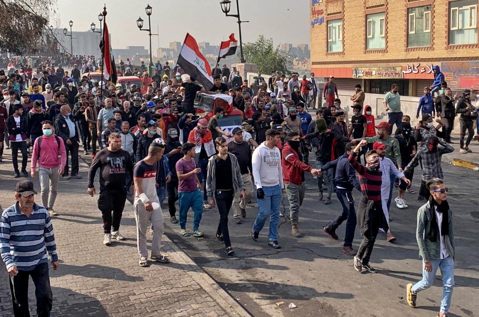 Mourners and protesters escort the flag-draped coffin of Munir Ali, whose family said was killed in anti-government demonstrations, during his funeral in Baghdad, Iraq, Sunday, Nov. 24, 2019. (AP Photo/Ali Abdul Hassan)