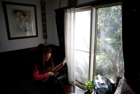 54-y-o Hiromi Tanaka holds a ukulele during an interview with Reuters at her house where she lives with her widowed mother in Tokyo, Japan March 1, 2017. REUTERS/Issei Kato