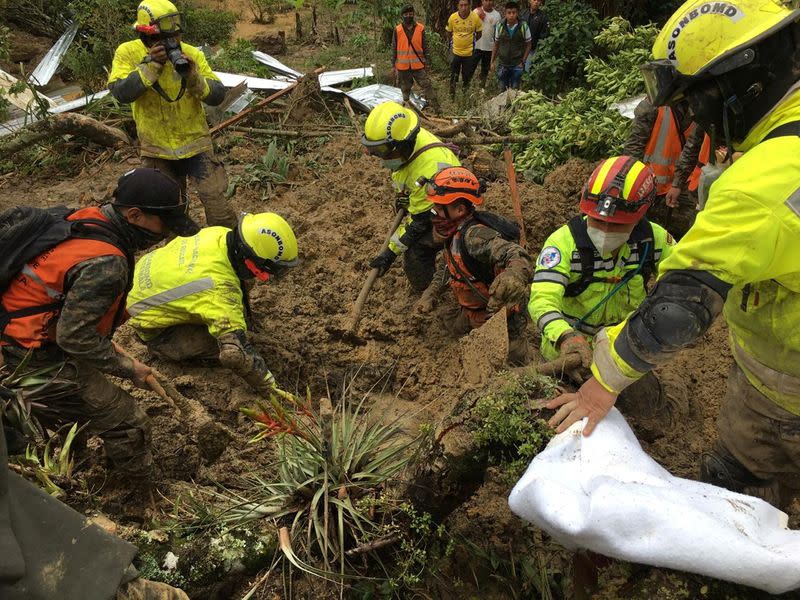 Guatemalan soldiers work to recover a body at area hit by a mudslide after the passage by Storm Eta, in Queja