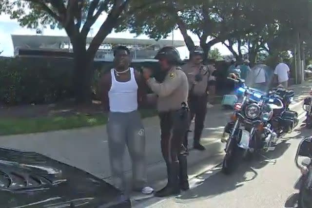 <p>Miami-Dade Police Department</p> Tyreek Hill (left) and two Miami-Dade police officers