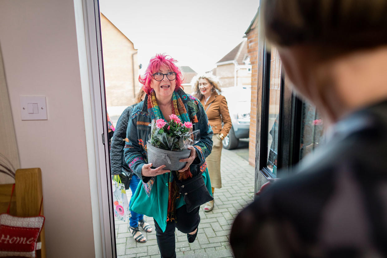 Friends Arriving for a Dinner Party With Flowers Getty Images/SolStock