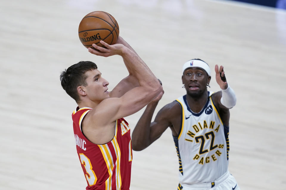 Atlanta Hawks' Bogdan Bogdanovic (13) shoots next to Indiana Pacers' Caris LeVert (22) during the first half of an NBA basketball game Thursday, May 6, 2021, in Indianapolis. (AP Photo/Darron Cummings)