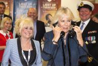 Britain's Camilla, Duchess of Cornwall (FRONT R) is watched by actress Barbara Windsor (FRONT L) as she speaks on the telephone at the annual ICAP charity day in the City of London December 3, 2013. REUTERS/Paul Grover/Pool (BRITAIN - Tags: ENTERTAINMENT BUSINESS SOCIETY ROYALS)