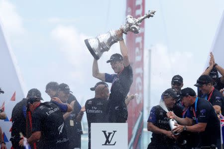 Sailing - America's Cup finals - Hamilton, Bermuda - June 26, 2017 - Peter Burling, Emirates Team New Zealand Helmsman celebrates holding up the America's Cup trophy after defeating Oracle Team USA. REUTERS/Mike Segar