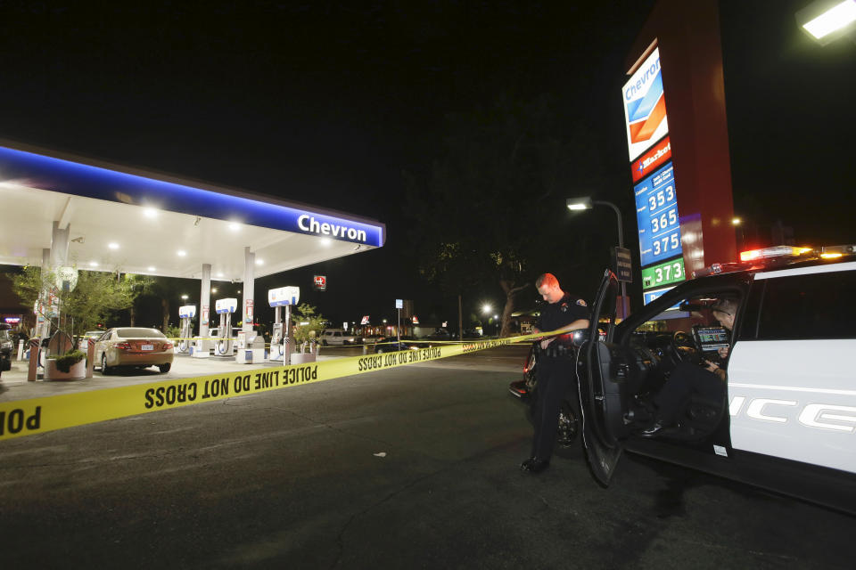 Garden Grove police stand watch at the scene of a stabbing in Garden Grove, Calif., Wednesday, Aug. 7, 2019. A man killed multiple people and wounded others in a string of robberies and stabbings in California's Orange County before he was arrested, police said Wednesday. (AP Photo/Alex Gallardo)