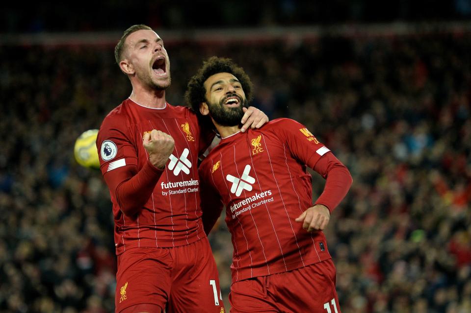 Liverpool's Egyptian midfielder Mohamed Salah (R) celebrates with Liverpool's English midfielder Jordan Henderson after scoring a penalty during the English Premier League football match between Liverpool and Tottenham Hotspur at Anfield in Liverpool, north west England on October 27, 2019. (Photo by STRINGER / AFP) / RESTRICTED TO EDITORIAL USE. No use with unauthorized audio, video, data, fixture lists, club/league logos or 'live' services. Online in-match use limited to 120 images. An additional 40 images may be used in extra time. No video emulation. Social media in-match use limited to 120 images. An additional 40 images may be used in extra time. No use in betting publications, games or single club/league/player publications. /  (Photo by STRINGER/AFP via Getty Images)