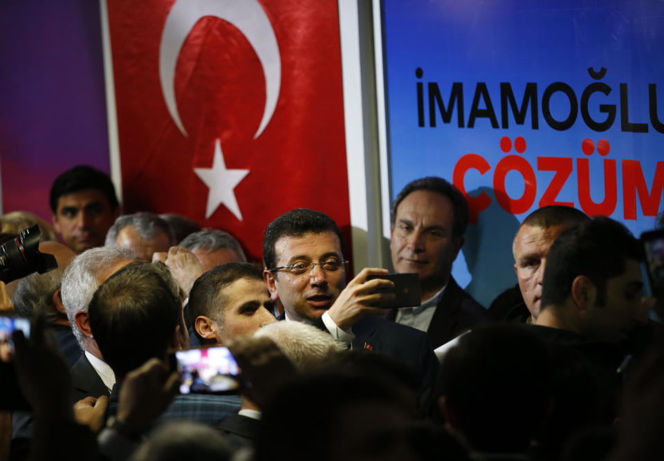 Ekrem Imamoglu, centre, the opposition, Republican People's Party's (CHP) mayoral candidate in Istanbul, is photographed by a supporter following a media conference in Istanbul, Tuesday, April 9, 2019. Turkey's President Recep Tayyip Erdogan's ruling Justice and Development Party, or AKP, says it will seek a re-run of last week's mayoral election in Istanbul, citing alleged irregularities. The party suffered a major setback in the elections. Opposition candidates won in Turkey's capital, Ankara, and squeezed out the ruling party in Istanbul. (AP Photo/Lefteris Pitarakis)