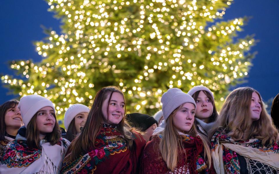 Carolers sing near the Christmas tree in Lviv, Ukraine