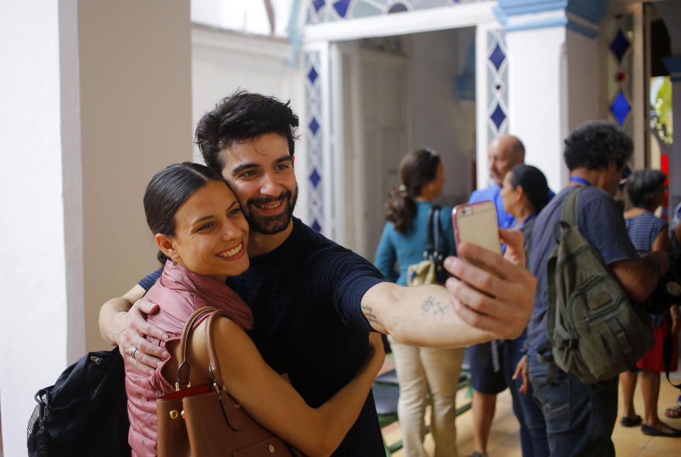 In this Oct. 30, 2018 photo, Cuban expatriate ballet dancers Rolando Sarabia and Yanela Piñera, left, take a selfie in Havana, Cuba. The stars' return to Cuba began during the warming between Cuba and the United States begun by presidents Barack Obama and Raul Castro in December 2014. A year or two later, a Cuban ballet official traveled to Miami and met with a group of former national dancers, who said they wanted to return to perform in Cuba. (AP Photo/Desmond Boylan)