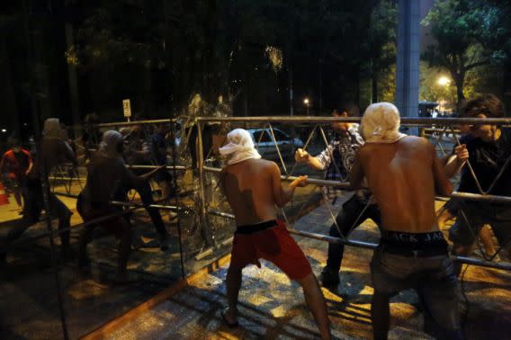 <p>Manifestantes chocan contra una barrera en el edificio del Congreso durante enfrentamientos con la policía. Quienes protestaban se oponen a un proyecto de enmienda constitucional que permitiría la reelección presidencial en Asunción, Paraguay, el viernes 31 de marzo de 2017. Algunos manifestantes lograron sobrepasar a la policía y llegar hasta el primer piso, donde prendieron fuego a muebles y papeles. La policía usó carros hidrantes y balas de goma para dispersar a quienes protestaban afuera del edificio, mientras los bomberos enfrentaban el fuego en el interior. (AP Foto/Jorge Saenz) </p>