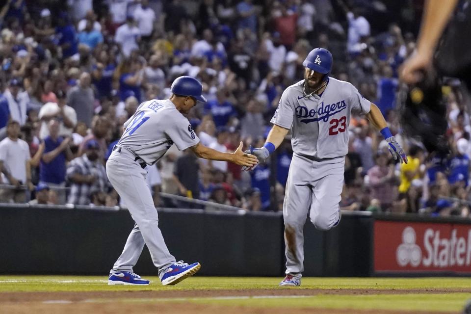 Los Angeles Dodgers' Steven Souza, right, slaps hands with third base coach Dino Ebel as Souza rounds the bases after hitting a home run against the Arizona Diamondbacks during the eighth inning of a baseball game Friday, June 18, 2021, in Phoenix. (AP Photo/Ross D. Franklin)