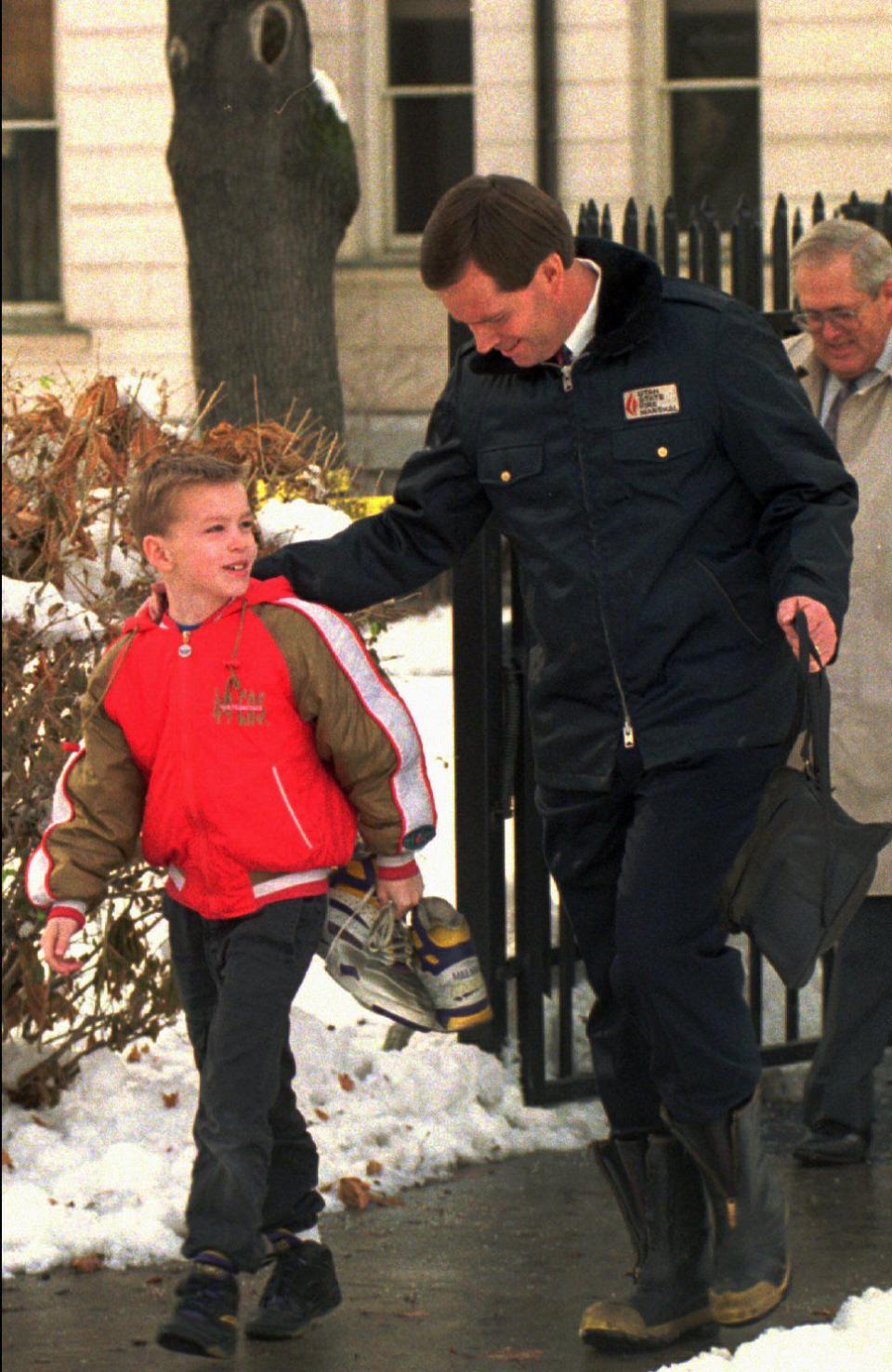 Gov. Mike Leavitt and his son, Case, salvage some items from the Governor’s Mansion after a Christmas tree fire on Dec. 15, 1993, in Salt Lake City. Case retrieved his favorite pair of basketball shoes, signed by Karl Malone. Gov. Leavitt got some shoes and a couple of suits. | Gerald W. Silver, Deseret News