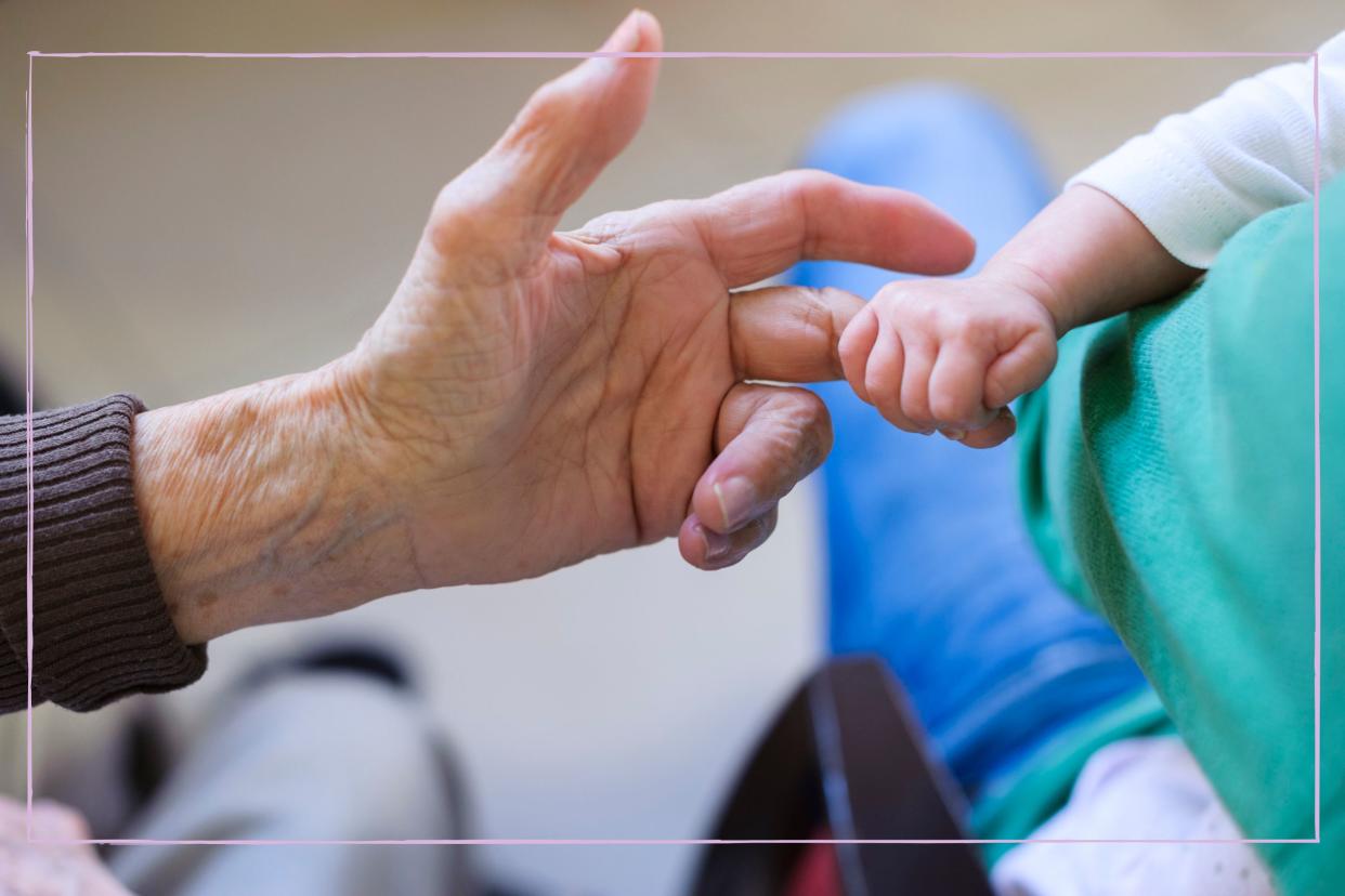  Grandparent holding baby's finger. 