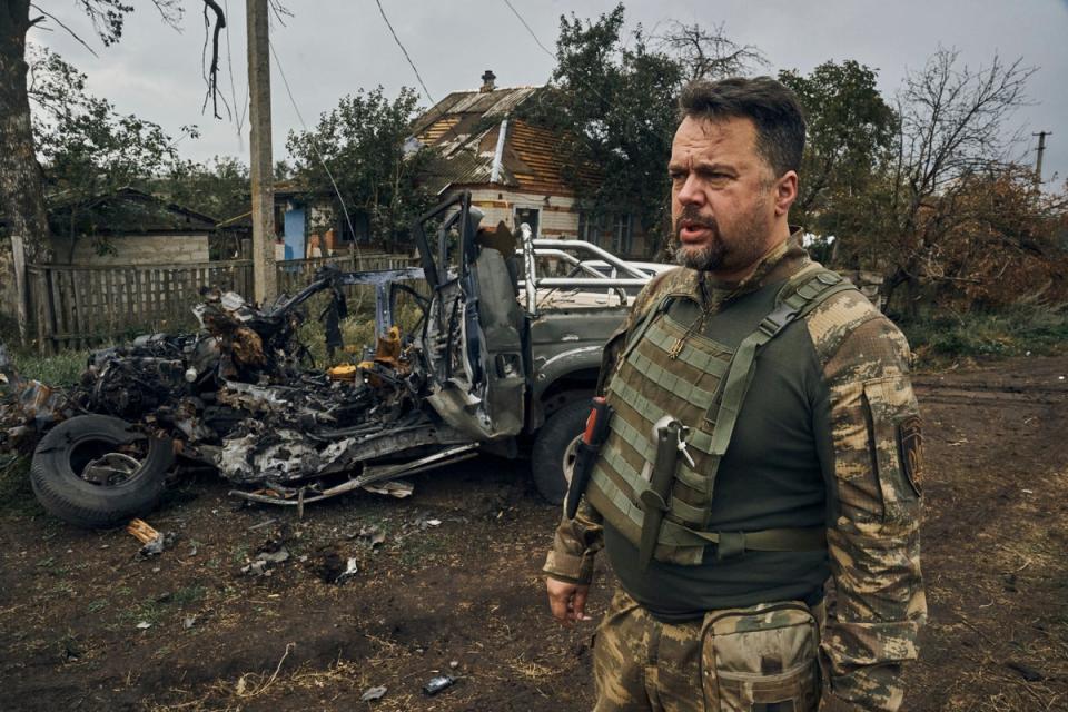 Ukrainian soldier looks on near an exploded car in the freed territory in the Kharkiv region, Ukraine (AP)