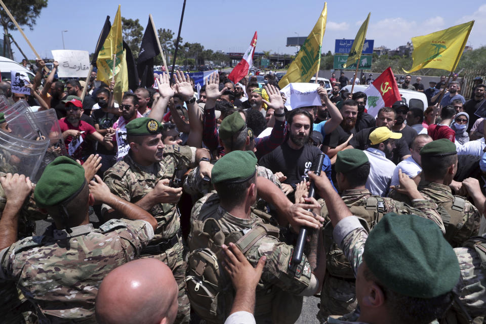 Hezbollah supporters scuffle with Lebanese army soldiers while protesting the visit by Gen. Frank McKenzie, the head of U.S. Central Command, outside ​​the Rafik Hariri International Airport in Beirut, Lebanon, Wednesday, July 8, 2020. (AP Photo/Bilal Hussein)