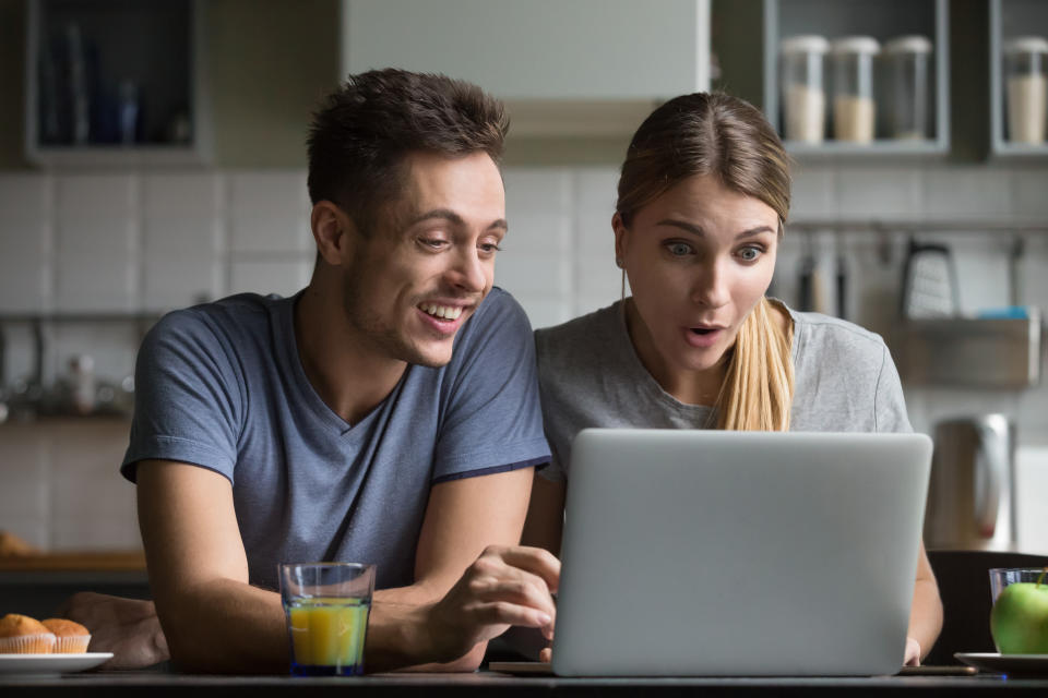 Surprised young couple look at laptop