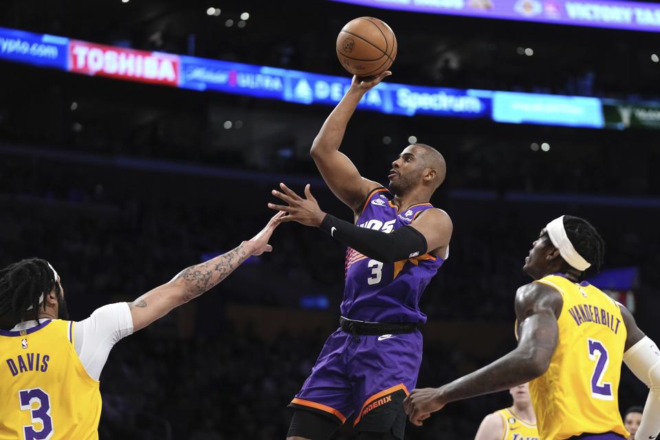 Phoenix Suns guard Chris Paul, center, shoots as Los Angeles Lakers forward Anthony Davis, left, and forward Jarred Vanderbilt defend during the first half of an NBA basketball game Wednesday, March 22, 2023, in Los Angeles. (AP Photo/Mark J. Terrill)