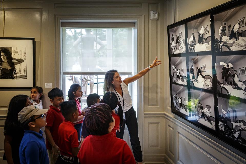 School programs coordinator Yelda Dougan describes some of Harry Benson's photography of The Beatles to West Gate Elementary students during a school trip at the Ann Norton House.