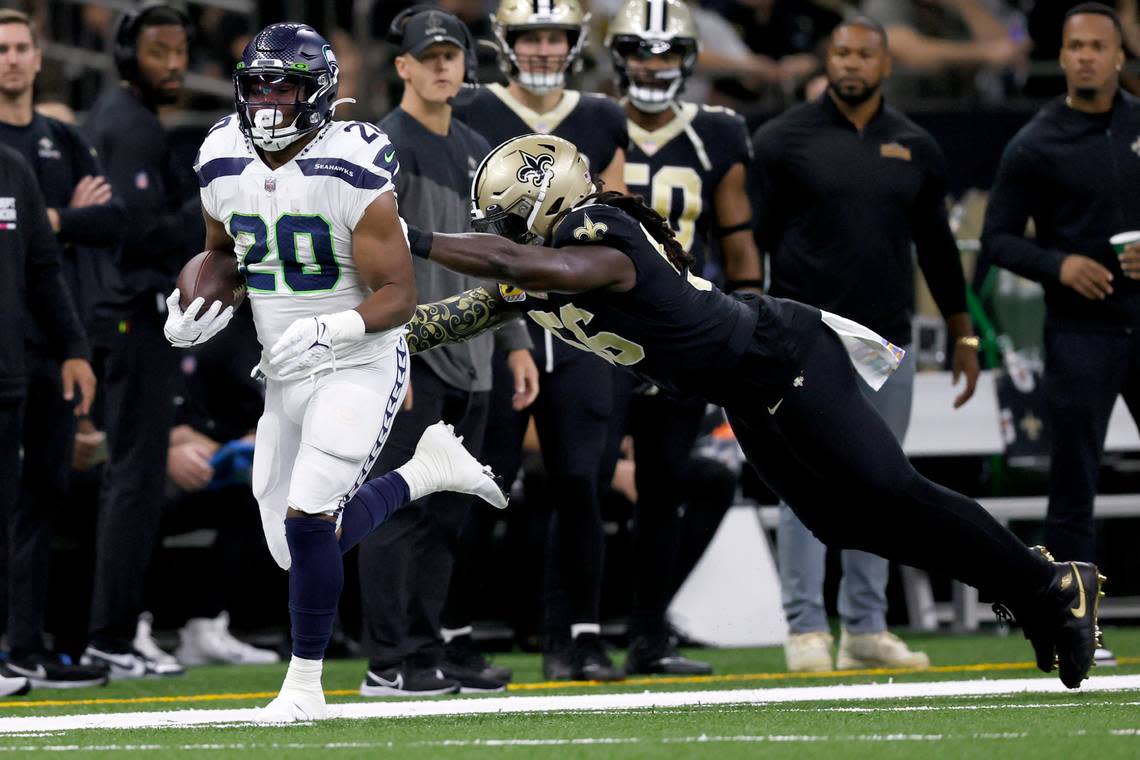 Seattle Seahawks running back Rashaad Penny runs past the outstretched arms of New Orleans Saints linebacker Demario Davis during an NFL football game in New Orleans, Saturday, Oct. 8, 2022. (AP Photo/Derick Hingle)