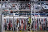 A person moves through clothing in the storage area at Rent the Runway's "Dream Fulfillment Center" in Secaucus, New Jersey