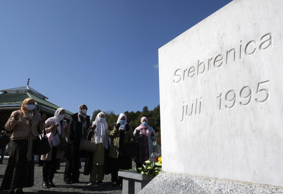 Bosnian filmmaker Jasmila Zbanic, third left, prays at the memorial cemetery in Potocari, before the first public showing of a film on the 1995 massacre in Srebrenica - "Quo Vadis, Aida?", in the eastern Bosnian town of Srebrenica, Oct. 10, 2020. The Srebrenica massacre was the culmination of Bosnia's 1992-95 war, which pitted the country's three main ethnic factions - Serbs, Croats and Bosnian Muslims. (AP Photo/Kemal Softic)