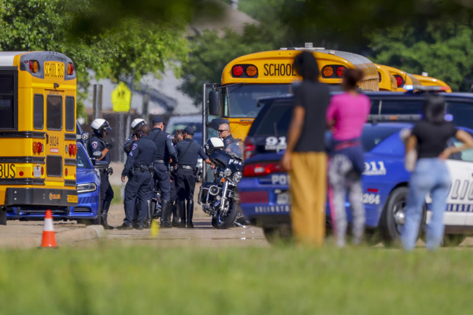 Onlookers wait outside Arlington Bowie High School after the school was placed on a lockdown due to a suspected shooting outside the school building, Wednesday April 24, 2024, in Arlington, Texas. (AP Photo/Gareth Patterson)