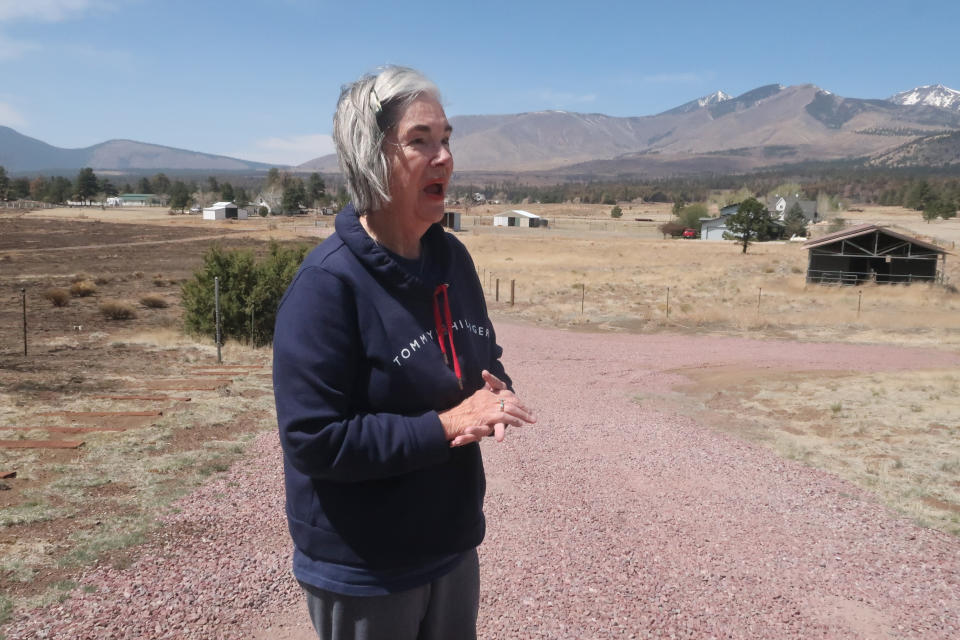 Harriet Young stands outside her home on the outskirts of Flagstaff, Ariz., Thursday, April 28, 2022. A massive wildfire that started Easter Sunday burned about 30 square miles and more than a dozen homes, hopscotching across the parched landscape. (AP Photo/Felicia Fonseca)