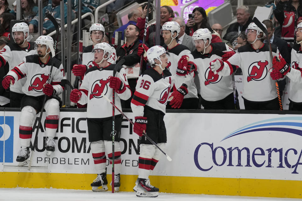New Jersey Devils center Jack Hughes (86) is congratulated by teammates after scoring a goal against the San Jose Sharks during the second period of an NHL hockey game in San Jose, Calif., Tuesday, Feb. 27, 2024. (AP Photo/Jeff Chiu)
