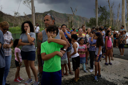 Residents wait for soldiers in UH-60 Blackhawk helicopters from the First Armored Division's Combat Aviation Brigade to deliver food and water during recovery efforts following Hurricane Maria, in San Lorenzo, Puerto Rico, October 7, 2017. REUTERS/Lucas Jackson