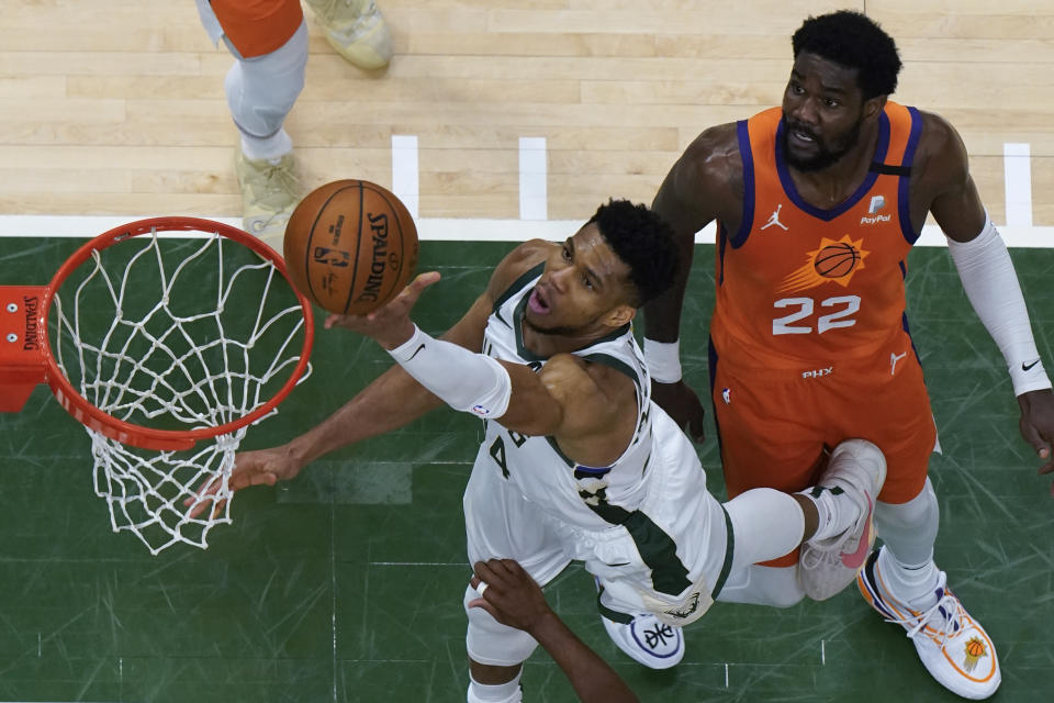 Milwaukee Bucks forward Giannis Antetokounmpo (34) drives on Phoenix Suns center Deandre Ayton (22) during Game 4 of basketball's NBA Finals in Milwaukee, Wednesday, July 14, 2021. (AP Photo/Paul Sancya, Pool)