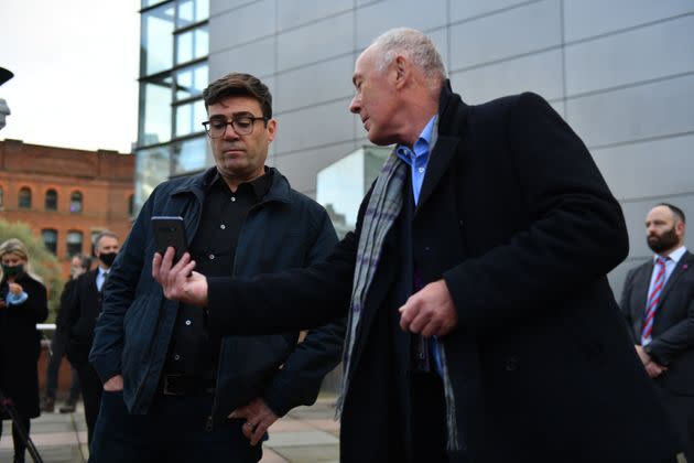 Greater Manchester mayor Andy Burnham (left) with leader of Manchester City Council Sir Richard showing him when the measures will come into force after speaking to the media outside Bridgewater Hall, Manchester.