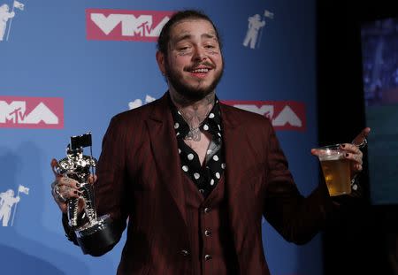 2018 MTV Video Music Awards - Photo Room - Radio City Music Hall, New York, U.S., August 20, 2018. - Post Malone poses backstage with his Song of the Year award for "Rockstar." REUTERS/Carlo Allegri